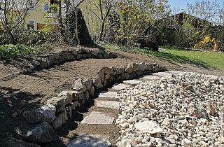 Trittplatten verlegt und kleine Trockenmauer erstellt