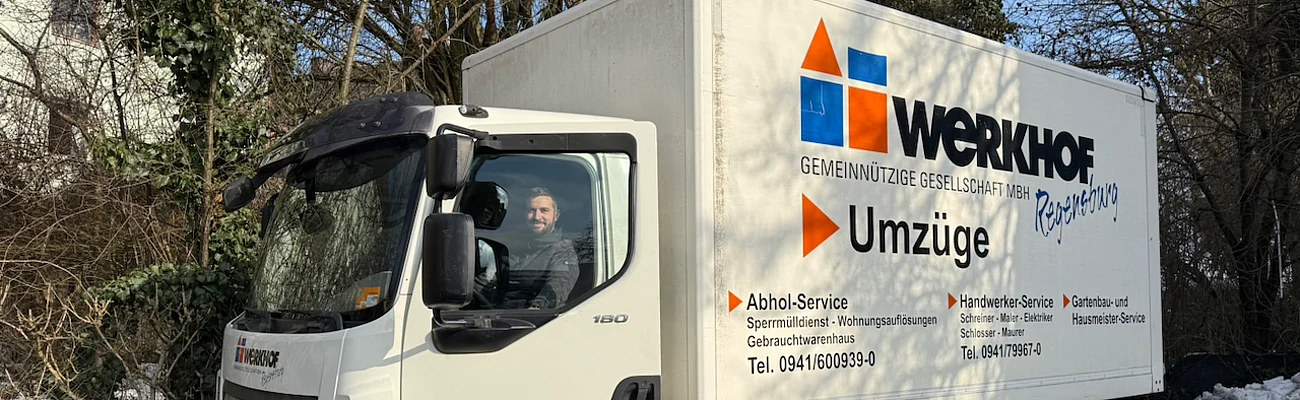 Unser LKW Fahrer sitzt im Werkhof LKW und schaut in die Kamera. Ihr zuverlässiger Partner für Transporte, Umzüge & Dienstleistungen