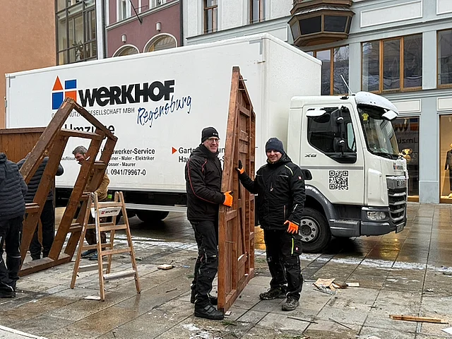 Beim Abbau der Weihnachtsbuden am Neupfarrplatz transportieren Geschäftsführer Dr. Michael Reil (links) und der künftige Geschäftsführer Peter Astaschenko eine Seitenwand der Bude zum LKW.