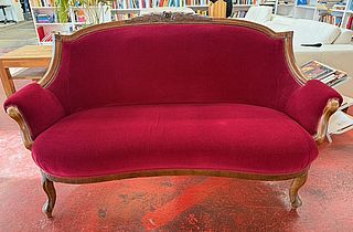 Als Beispiel zu sehen ist eine rote Couch im Gebrauchtwarenhaus