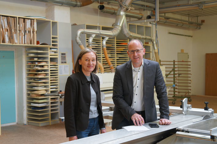 Geschäftsführer Peter Astaschenko und Prokuristin Lydia Faltermeier besprechen sich an einer Säge in der Schreinerwerkstatt des Werkhof Regensburg.
