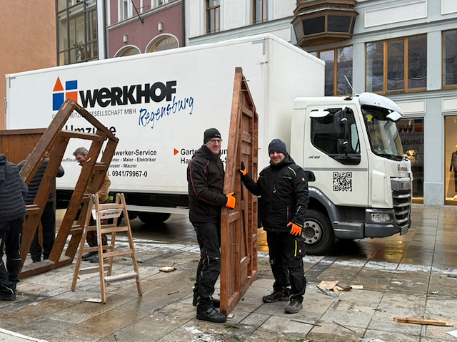 Beim Abbau der Weihnachtsbuden am Neupfarrplatz transportieren Geschäftsführer Dr. Michael Reil (links) und der künftige Geschäftsführer Peter Astaschenko eine Seitenwand der Bude zum LKW.