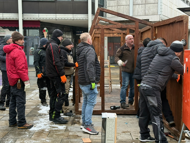 Teamarbeit beim Rückbau: Während einige Mitarbeitende des Werkhof Regensburg die Seitenteile der Buden abbauen, warten andere darauf, die Teile gemeinsam zum LKW zu transportieren.